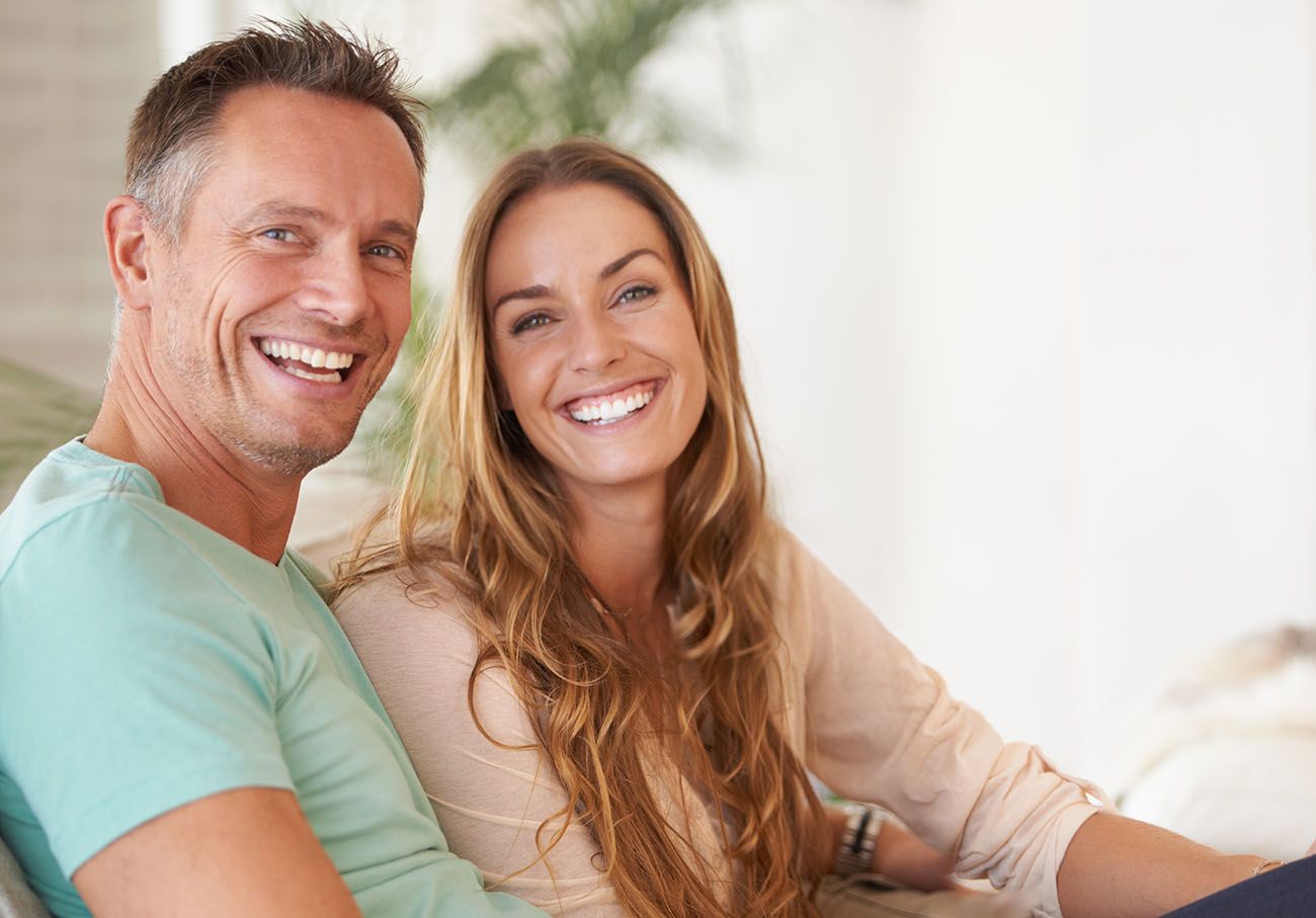 Smiling couple showcasing healthy teeth, emphasizing the benefits of dental care and root canal therapy at Sandy Springs Dentistry.