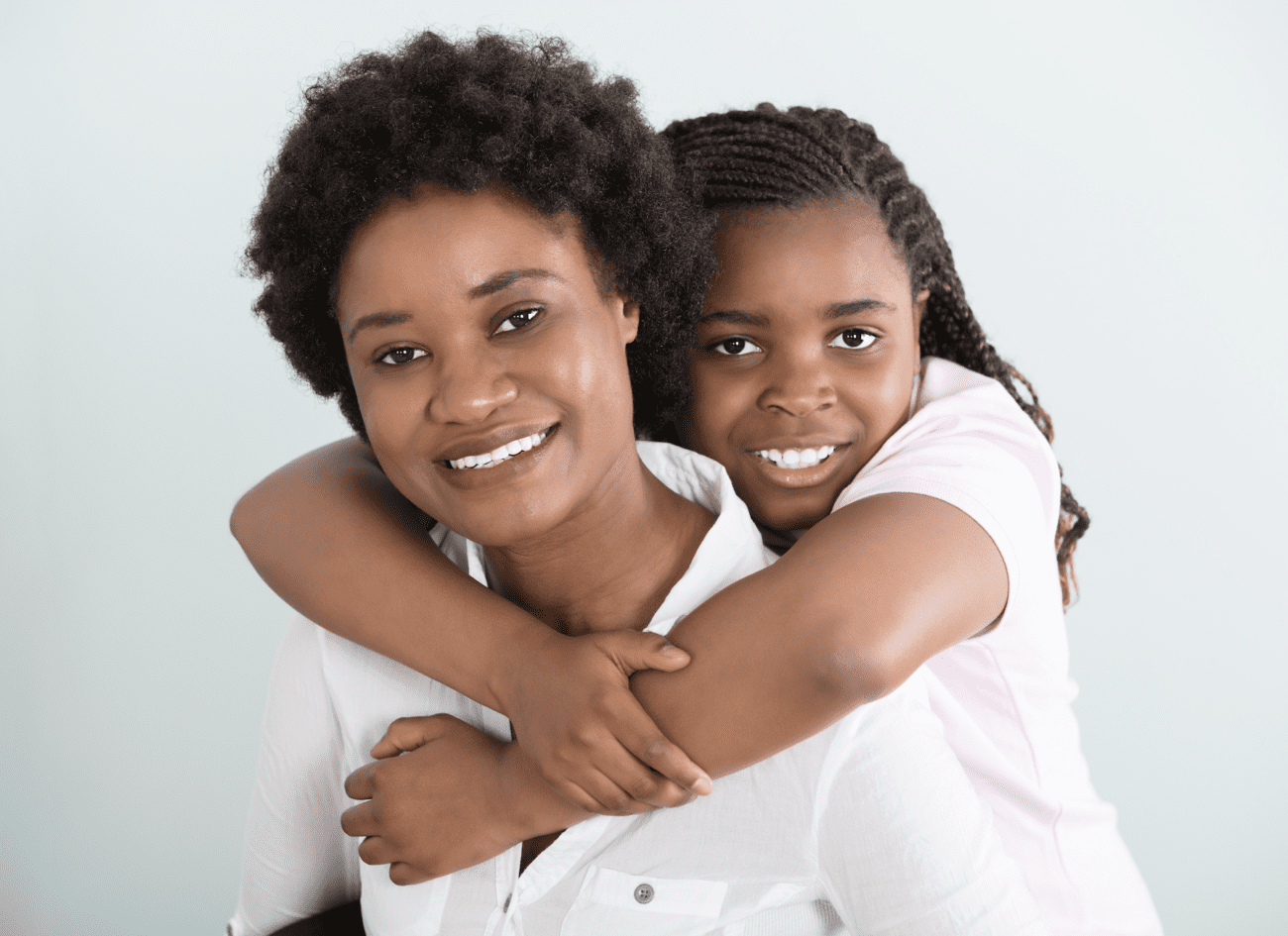 Smiling mother and daughter embracing, representing family care and comfort, relevant to dental health and non-surgical root canal treatment.